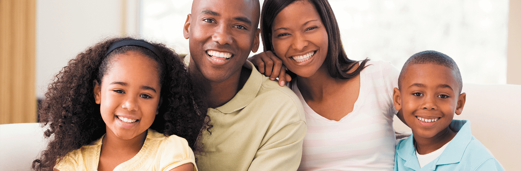 Smiling family seated on a couch